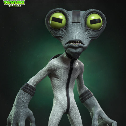 Close-up of the Grey Matter figure showing large green eyes, textured skin, and sleek suit detail with a sci-fi background.