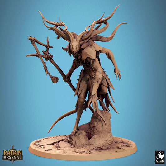 Front view of the Muck Priest ratfolk miniature standing on a rocky base, gripping a ritual staff and showing his large spiraling horns, elongated claws, and armored robes.