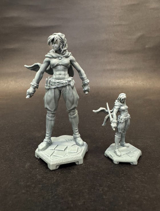 Two unpainted models of Moriah the Thief shown side-by-side in different scales, each posed confidently with a dagger and cloak.