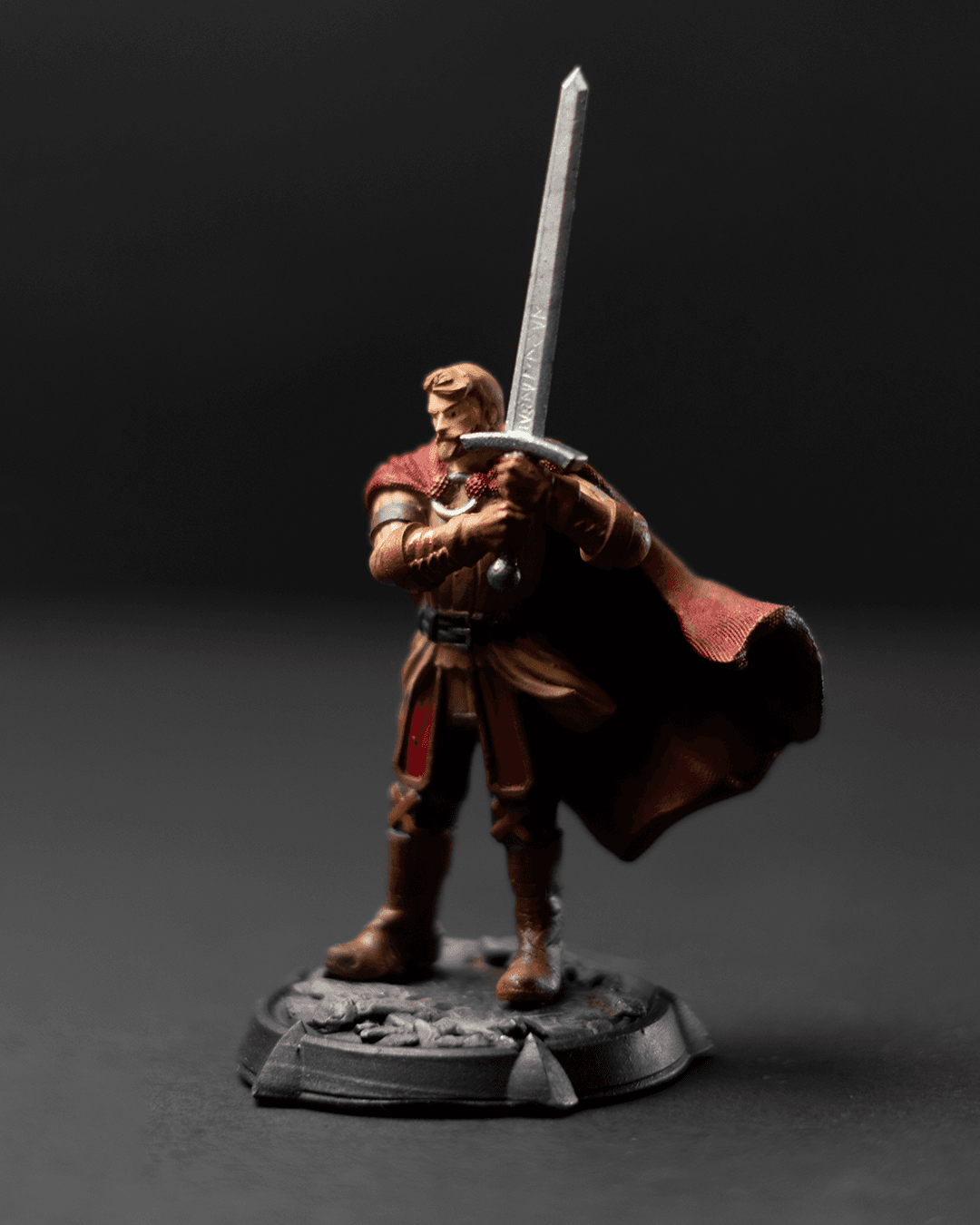 Trevor Astorio miniature holding a large sword, wearing armor with a flowing cape, standing in a commanding pose.