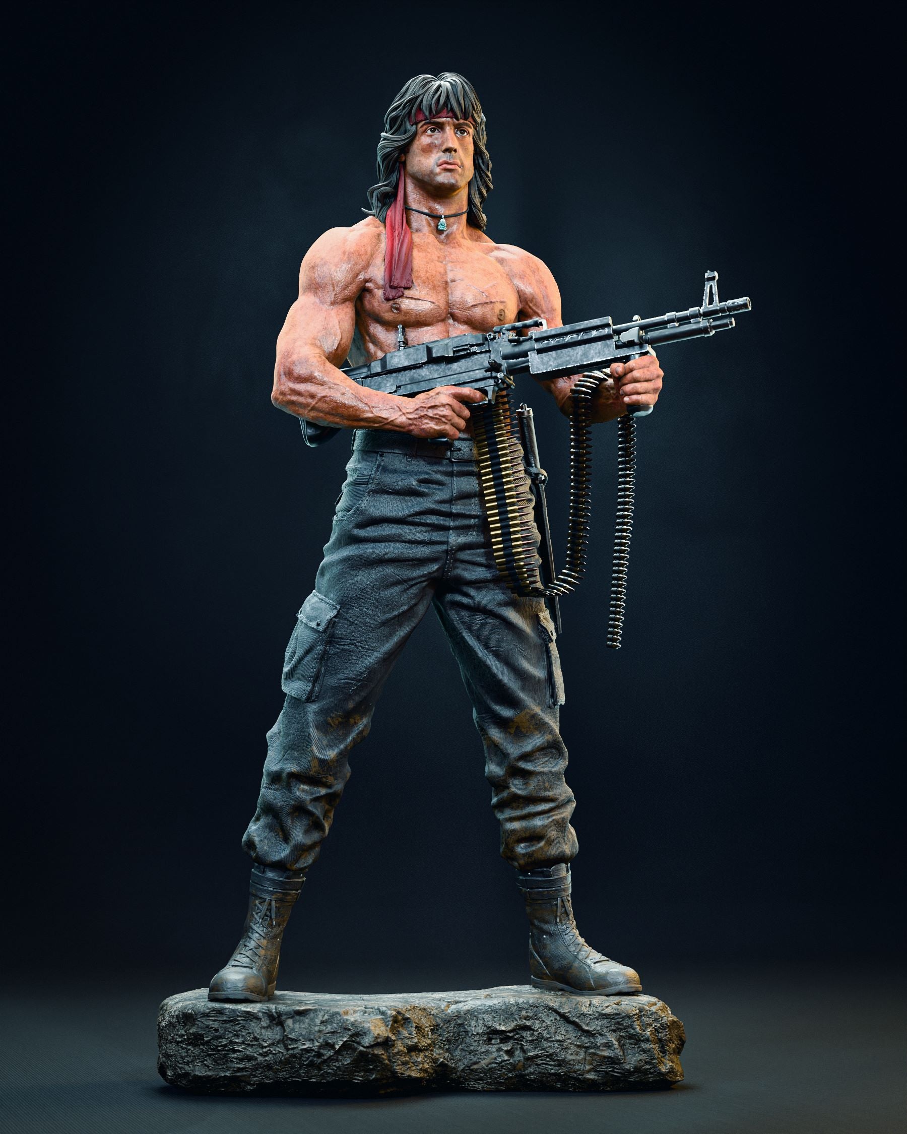 Full-body collectible figurine of Sylvester Stallone as Rambo, standing confidently on a rocky base with a machine gun in hand, dressed in combat pants and boots.