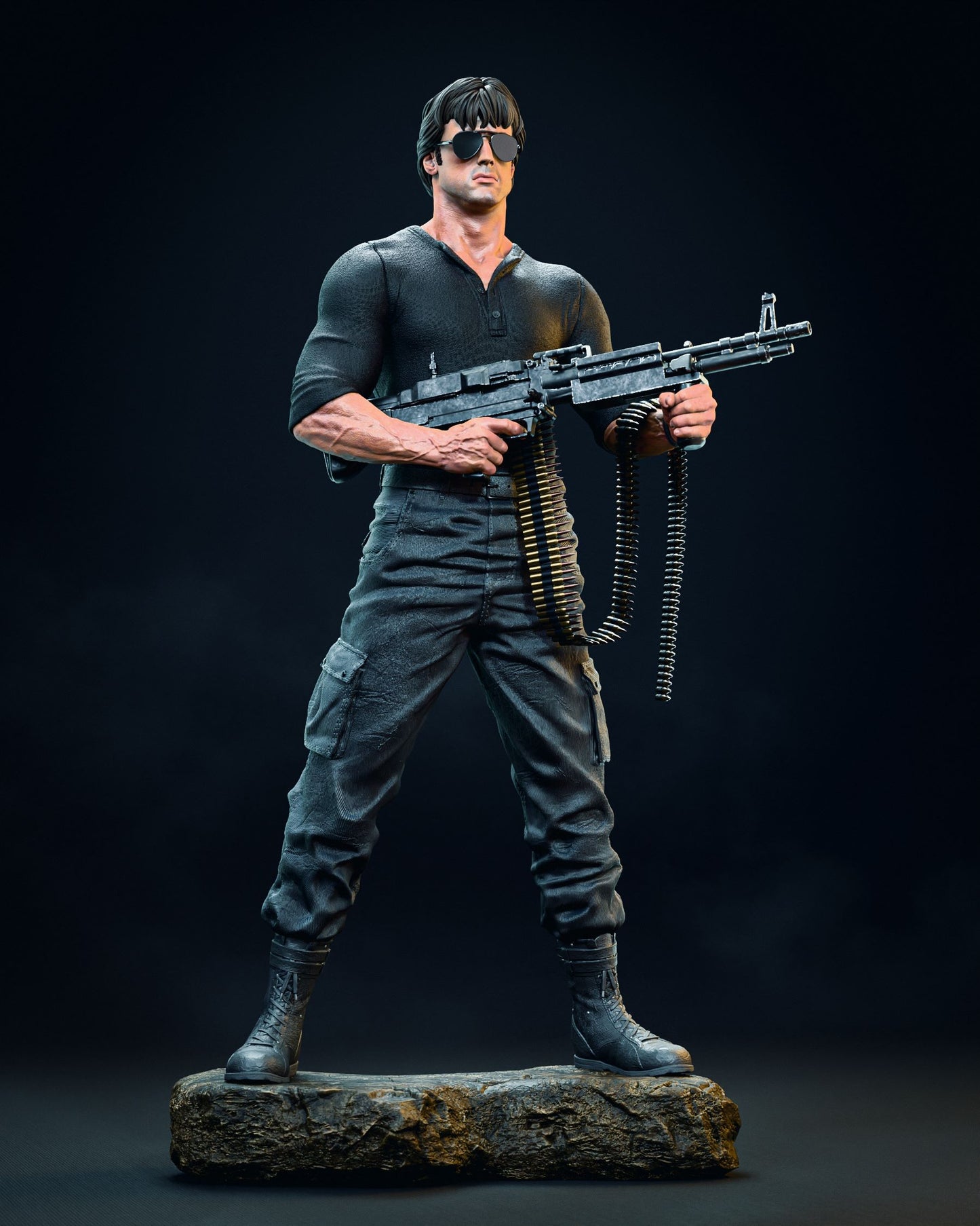 Full-body collectible figurine of Sylvester Stallone in his role as Cobra, wearing a dark shirt and sunglasses, holding a machine gun with a belt of bullets on a rugged base.