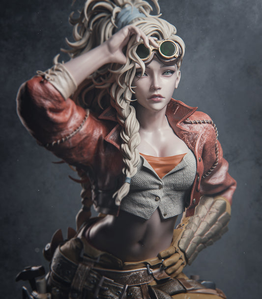 close-up of Gemma from Monster Hunter Wild wearing goggles, a red jacket, and braided hair with a confident expression.