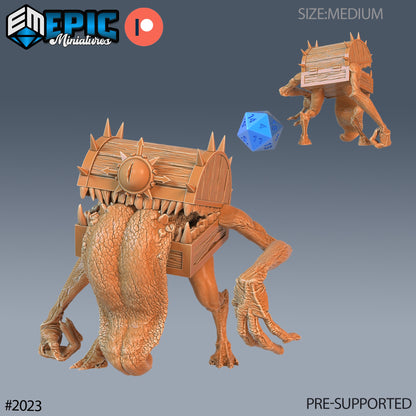 Chest mimic front and back view, showing tongue lolling out and clawed hands, positioned with a scale die for size.