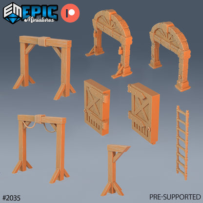 A collection of dwarf mine scatter terrain pieces including stone arches, gallows, a signpost, ladders, and barred wooden doors, designed for fantasy TTRPG settings.