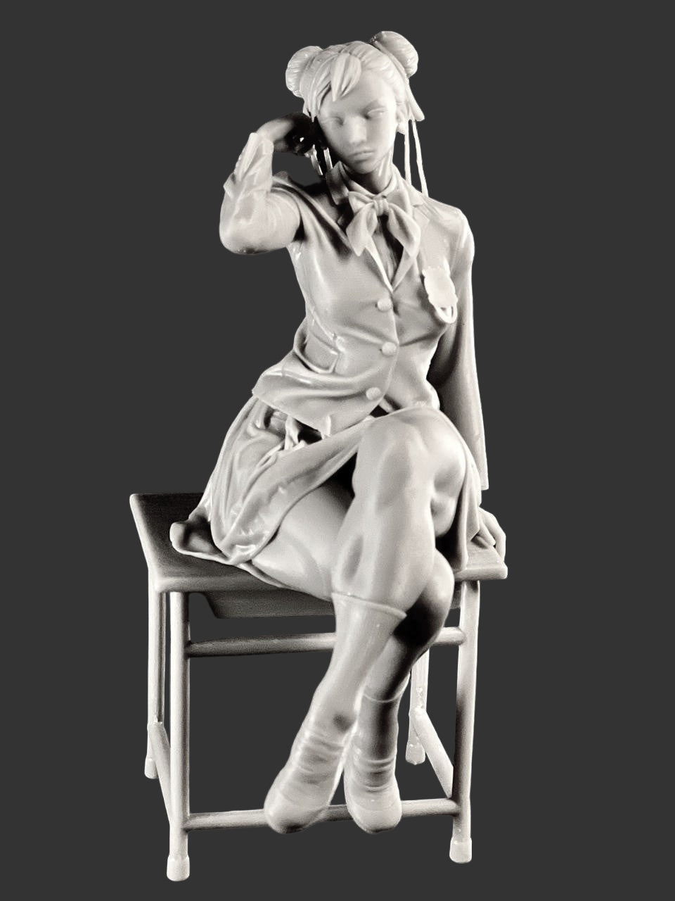 Chun-Li Street Fighter 1:6 figure grey resin print seated on desk showing uniform details, crossed legs, hairstyle, and classroom chair sculpt.