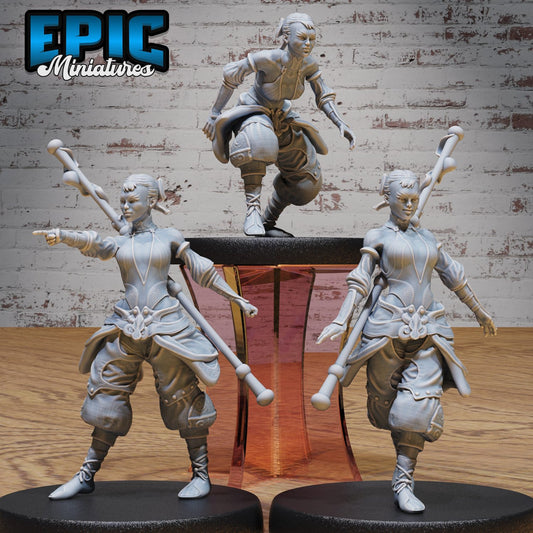 A set of three female monk adventurer miniatures in various poses: walking, crouched, and commanding. Each character carries a staff and wears detailed robes, enhancing immersion in fantasy RPG settings.