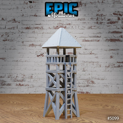 Wooden prison watch tower miniature with timber cross‑beam frame, ladder, and roofed lookout platform; 3D‑printed terrain by Epic Miniatures.
