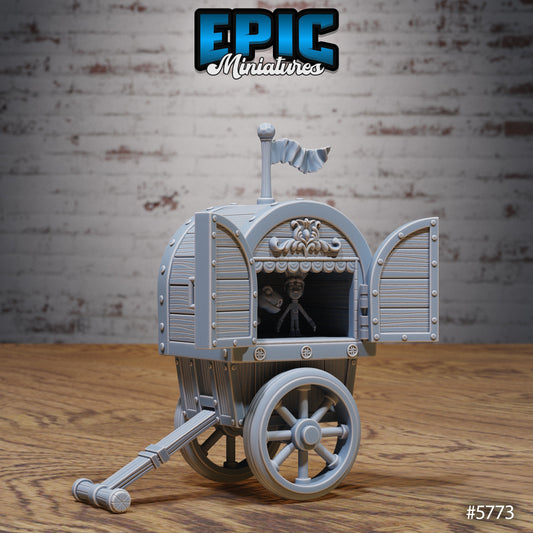 Mobile Theater Cart miniature scatter terrain featuring an ornate two-wheeled wagon with a puppet figure inside, decorative trim, and open stage doors topped with a waving flag.
