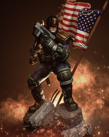 Judge Dredd figure in armored pose aiming gun forward with dual American flags waving behind him, standing on a cracked base.