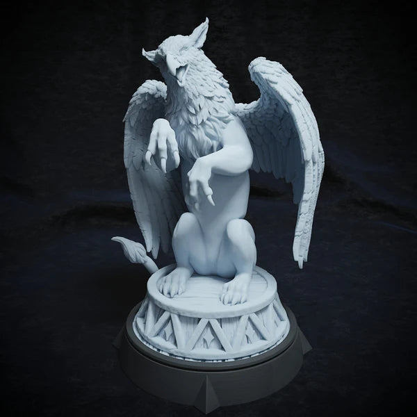 Front view of circus griffin figurine, sitting regally on a pedestal with wings spread.