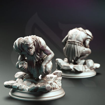 A crouched Trogg Cannibal miniature holding a skull, with a menacing expression and hunched stance on a rocky base.