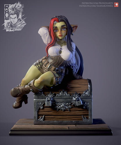 Fully clothed Goblin Angry collectible figurine, featuring detailed fantasy attire and a playful expression, sitting on a treasure chest.