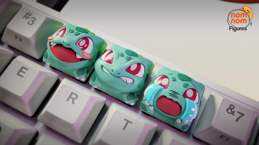 Side view of three Bulbasaur keycaps on keyboard, showing happy, angry, and crying expressions