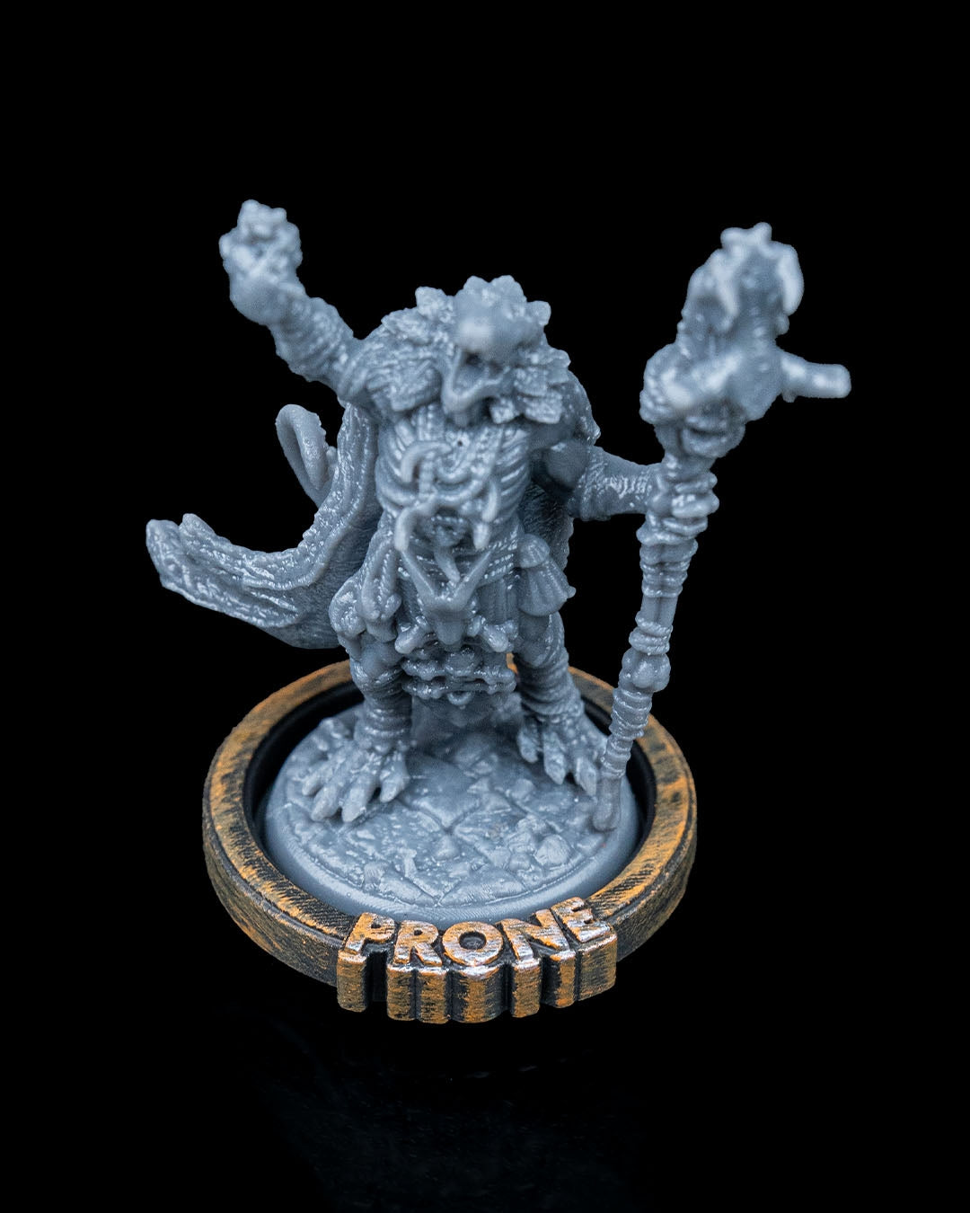 TTRPG miniature standing on a base with 'PRONE' condition ring attached, showing how the ring fits snugly around the miniature's base, ideal for Dungeons & Dragons or Pathfinder.
