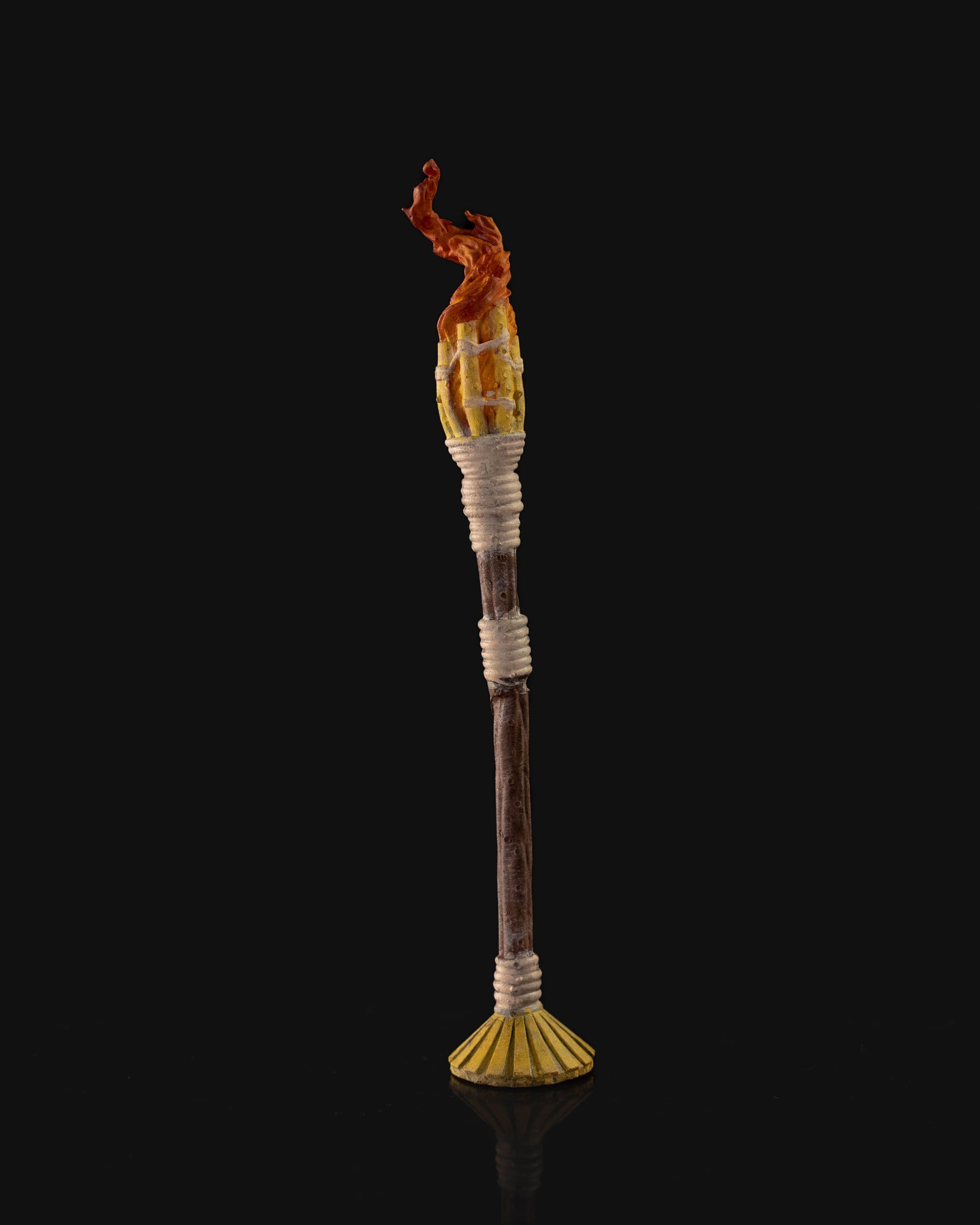 A flaming torch miniature for tabletop RPGs, featuring detailed rope bindings and a realistic flame design.