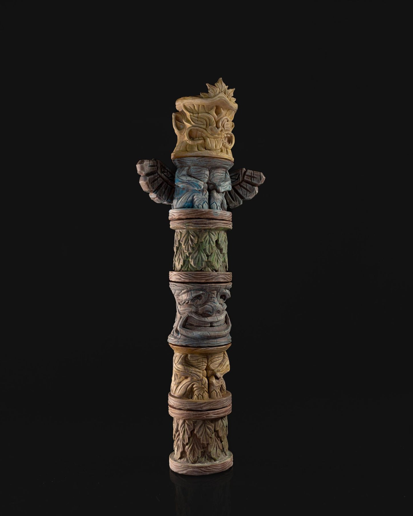 A carved totem pole miniature with tribal faces, perfect for adding thematic props to tabletop RPG settings.