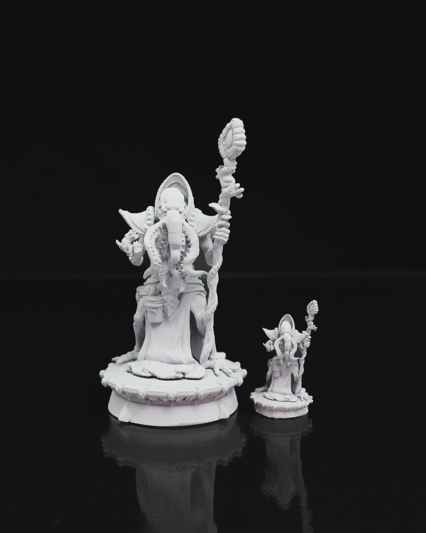 Mind Flayer miniature holding a staff adorned with mystical details, with tentacled face and elaborate robes, standing on a decorated base.