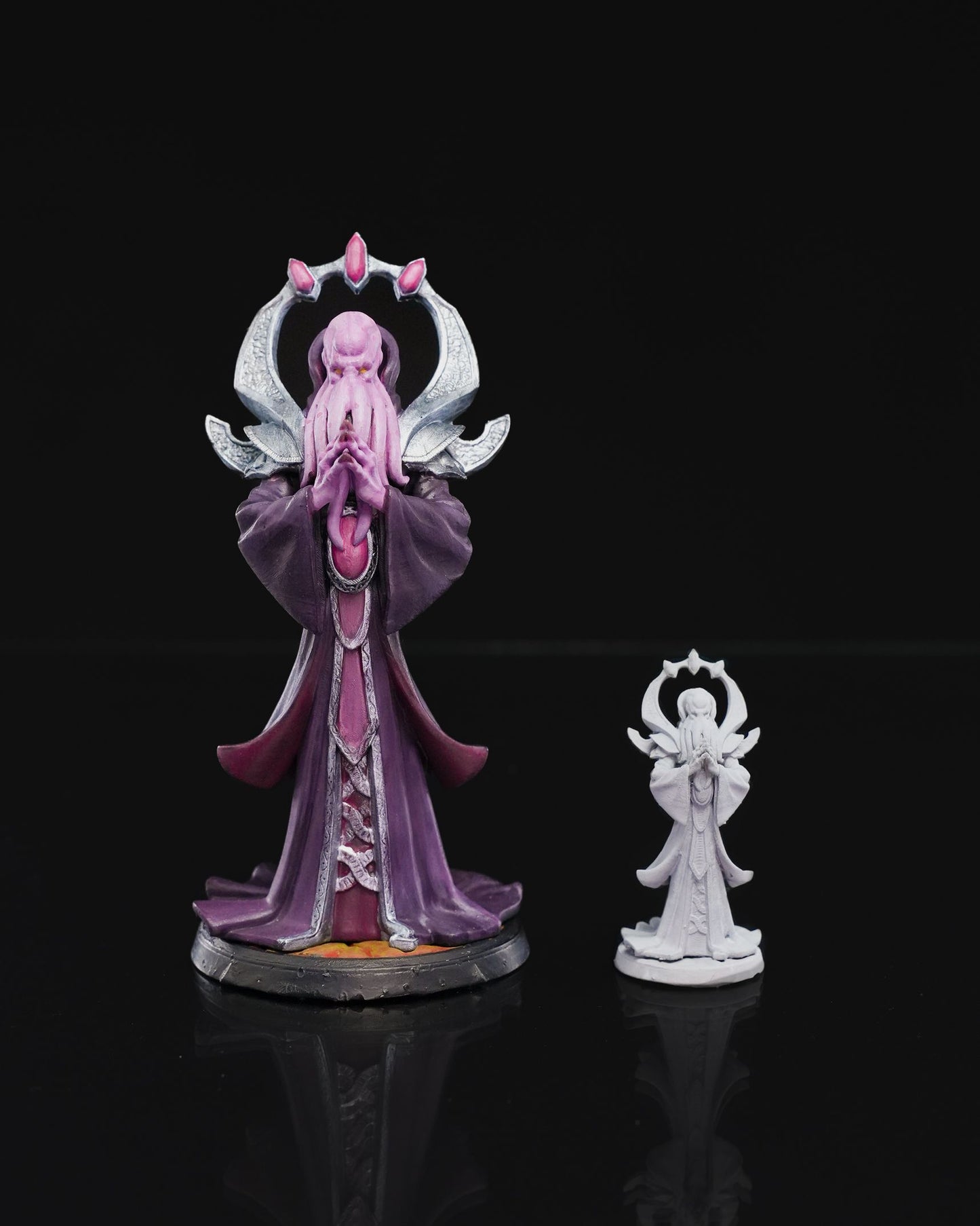 Mind Flayer miniature in a meditative pose with tentacled face, hands clasped, and ornate headpiece, wearing flowing robes, standing on a textured base.