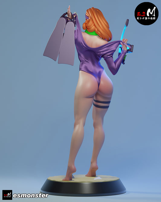 Daphne Divesuit painted 1:6 scale figure back view wearing purple divesuit, fins in hand, long hair with headband, and sandy circular display base.