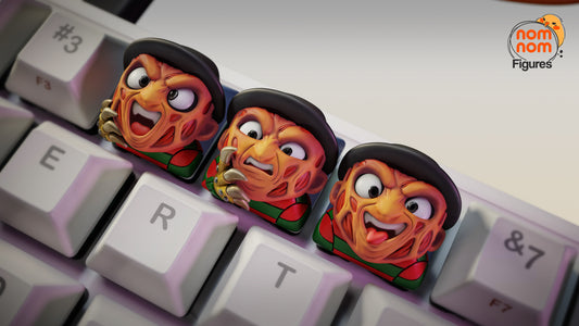 Close-up of Freddy Krueger keycaps on keyboard showing expressive faces and detailed sculpting – NomNom Figures Halloween collection.