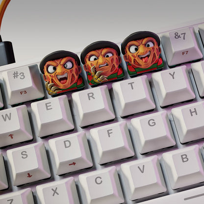 Freddy Krueger Halloween keycaps on mechanical keyboard featuring three variations with burned faces and clawed gloves – NomNom Figures collectible keycap set.