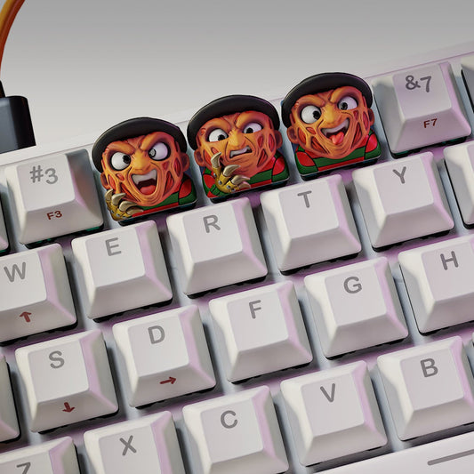 Freddy Krueger Halloween keycaps on mechanical keyboard featuring three variations with burned faces and clawed gloves – NomNom Figures collectible keycap set.