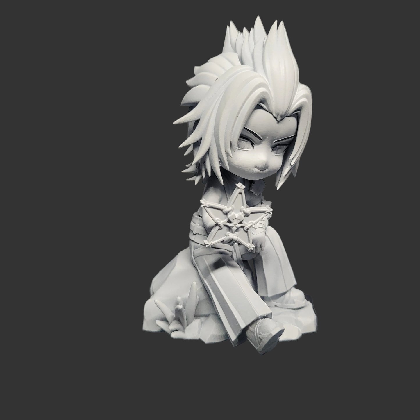 Unpainted Chibi Terra Kingdom Hearts figure seated on a rock holding a Wayfinder, showing sculpted hair volume, facial details, clothing folds, and chibi proportions