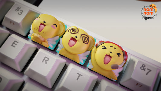 Angled shot of the Keroberos keycaps installed on a keyboard, showcasing their expressive designs—Keroberos happily munching, dazed with spiral eyes, and singing with a headset.