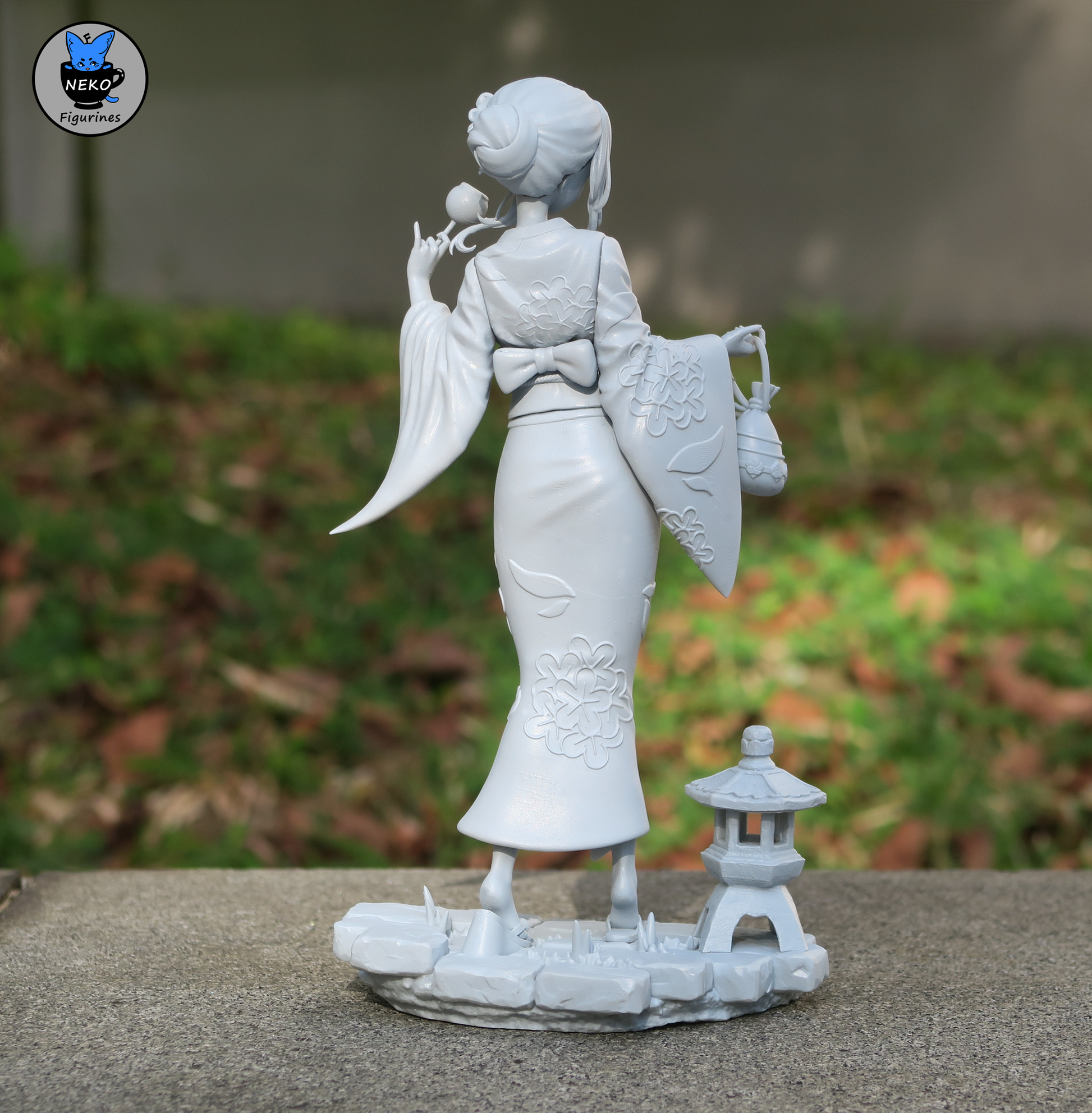 Rear view of Marin Kitagawa figurine in traditional yukata with obi bow and hair accessory, standing next to a stone lantern.