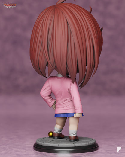 Rear view of chibi Momo Ayase showing long layered hair, pink sweater, and small base with gold ball detail.