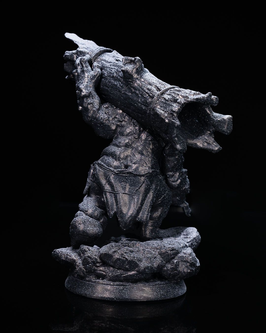 Back view of Orthos the Troll miniature, showcasing the massive log he carries and the detailed texture of his skin and attire.