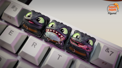 Close-up of Toothless artisan keycaps with large green eyes and detailed scales for mechanical keyboards.