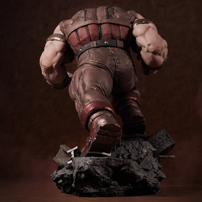 Rear view of painted Juggernaut collectible showing muscular back, leather textures, and rock base with crushed tire and bolts.