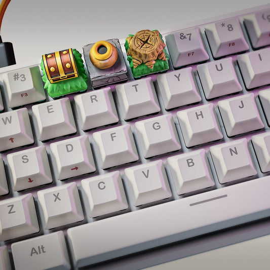 mechanical keyboard with three zelda inspired artisan keycaps including treasure chest keycap, pot keycap, and tree stump seal keycap installed on num row