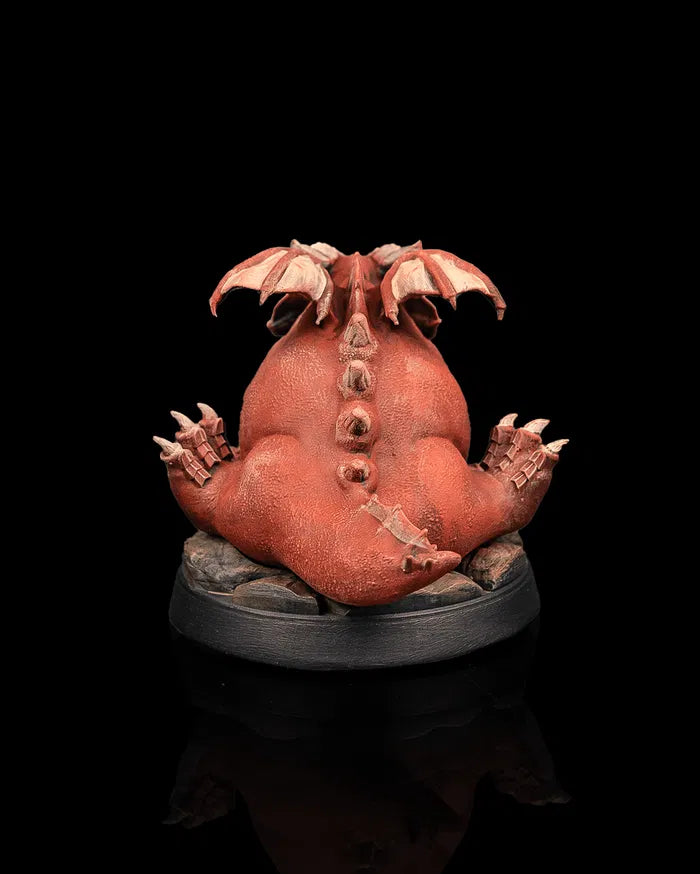 Young red dragon creature miniature rear view from Beldrad's Bag of Beasts showing rounded tail, folded wings, thick scales, and comically bulky dragon anatomy for tabletop roleplaying games