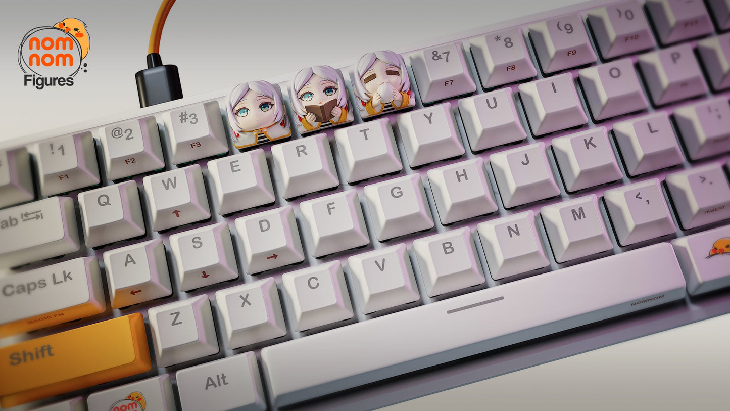 Full view of a mechanical keyboard with three Frieren keycaps placed on the E, R, and T keys, standing out against the white keyboard with colorful anime-inspired designs.