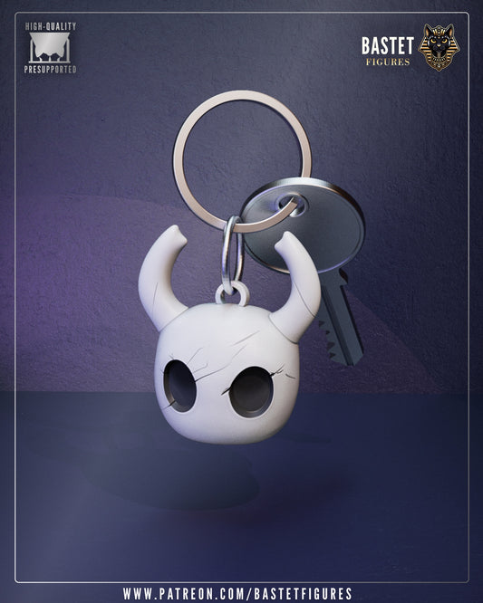 Hollow Knight Mask keychain from Hollow Knight featuring the horned mask design, hollow eyes, and smooth sculpted finish attached to a metal keyring