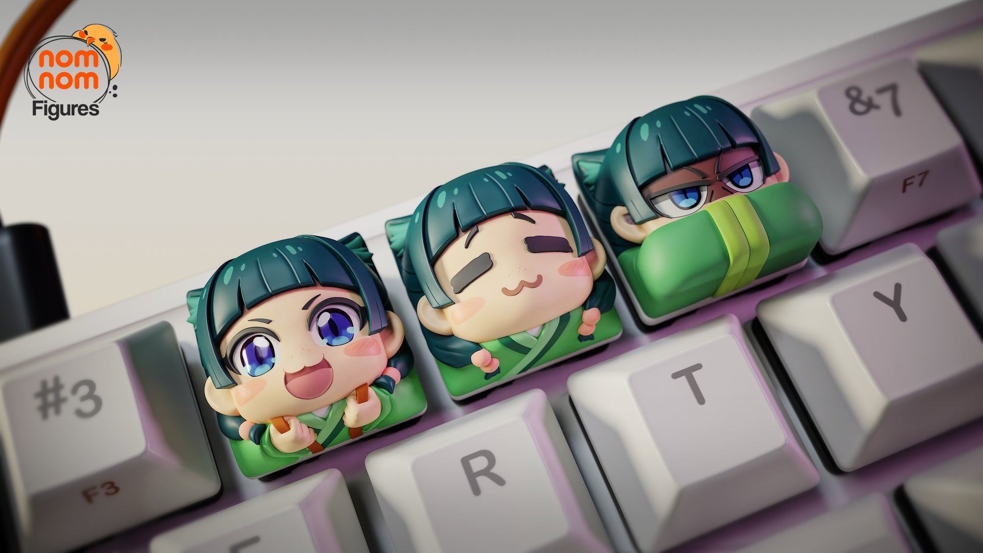 Close-up of three Maomao collectible keycaps inspired by Apothecary Diaries, featuring joyful, relaxed, and serious chibi faces, placed across the E, R, and T keys on a mechanical keyboard.