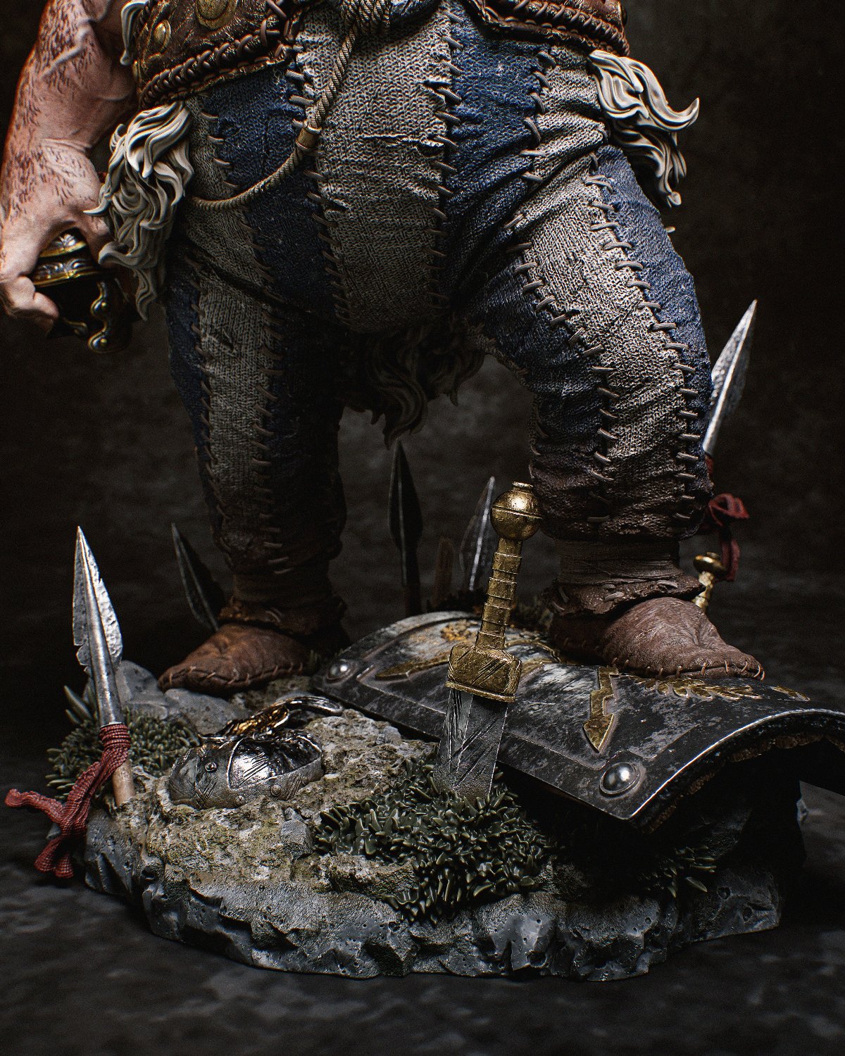 Detailed shot of the base featuring intricate elements like shattered shields, swords, and lush grass beneath Obelix's feet.