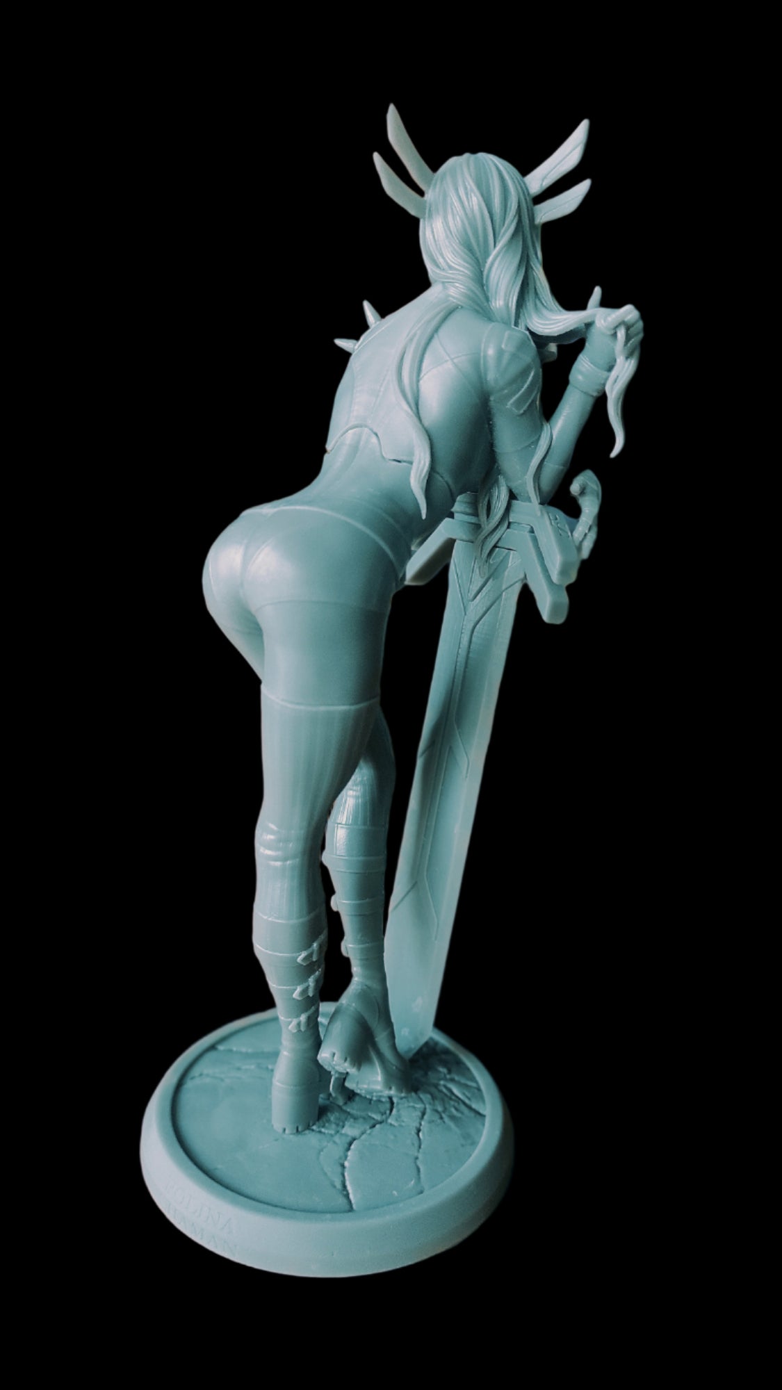 Rear view of unpainted Magik figure in 1:8 scale, leaning forward on a sword, wearing detailed boots and armor, standing on a cracked base.