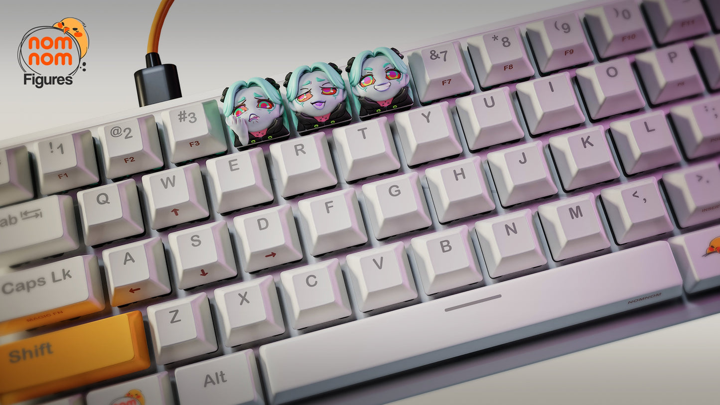 Angled view of Rebecca keycaps with pastel lighting on a mechanical keyboard, showing her iconic expressions.